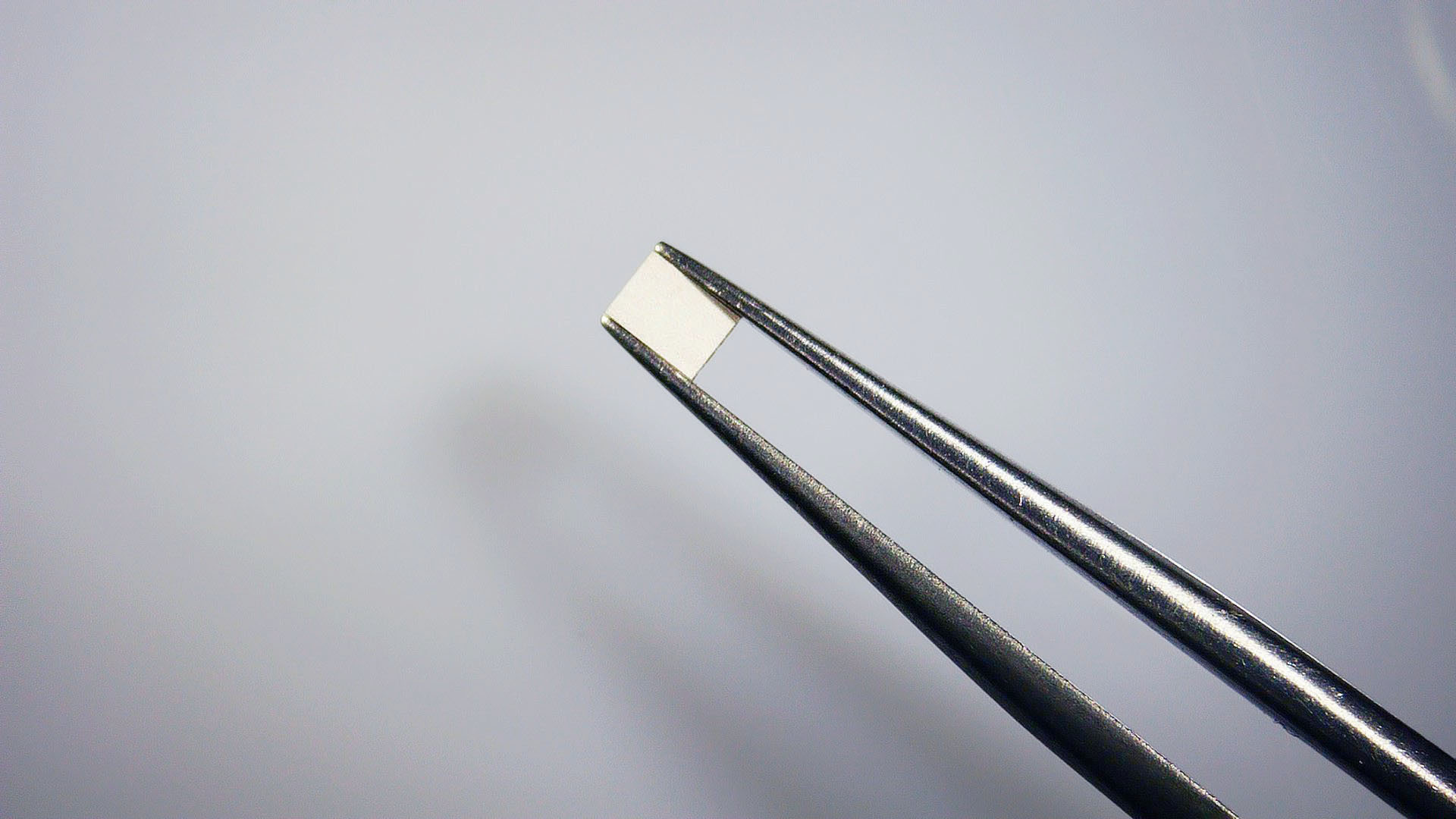 Leadless NTC thermistor chip held with tweezers